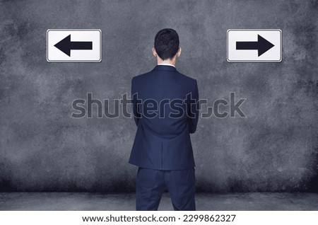 Back, arrow and direction with a business man planning or brainstorming a decision while in doubt on a wall background. Confused, challenge or strategy with a male employee thinking of a solution