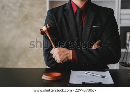 concept of justice and law A male judge in the courtroom on a wooden table and a male counselor or lawyer working in the office. Law, advice and justice concepts.	