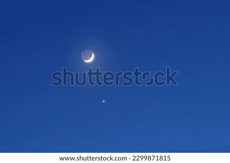 Venus next to the moon in the night starry sky. The new moon and the planet Venus move across the sky from evening to night
