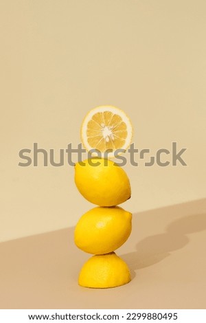 A pyramid of juicy yellow lemons on a beige background. Creative concept of fruits, citrus fruits.  Royalty-Free Stock Photo #2299880495