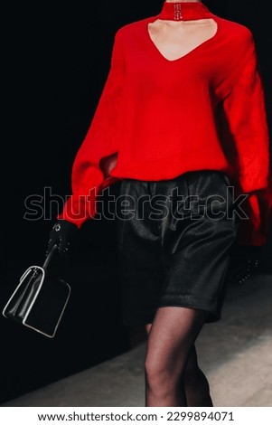 Fashion model woman wearing red blouse and black shorts. Casual stylish female clothes concept. Fashion week catwalk fashion details
