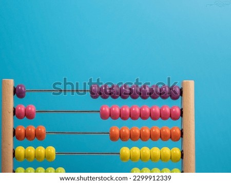 Wooden abacus on a blue background, Wooden abacus for children. Wooden abacus close-up. Royalty-Free Stock Photo #2299912339