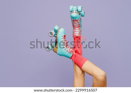 Close up cropped raised up female legs in blue rollerblades rollers isolated on plain light purple violet wall background studio. Summer sport lifestyle leisure concept. Copy space advertising mock up