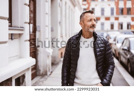 Best Ager Man Standing in the City and Looking Sideways Royalty-Free Stock Photo #2299923031