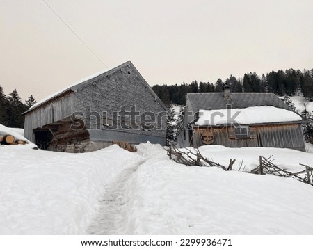 Idyllic old traditional Swiss mountain huts in a fresh snow cover over the Lake Walen or Lake Walenstadt (Walensee), Amden - Canton of St. Gallen, Switzerland (Schweiz)