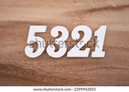 White number 5321 on a brown and light brown wooden background.