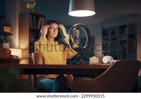 Young vlogger and content creator shooting a video for her followers, social media and communication concept Royalty-Free Stock Photo #2299950515