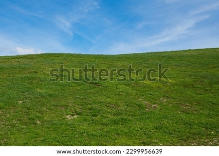 View of rolling green hills and blue sky in the spring season, Italy Royalty-Free Stock Photo #2299956639