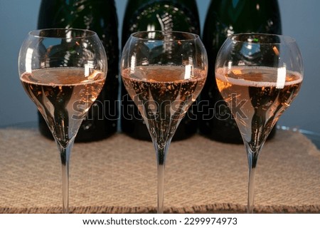 Tasting of rose brut Champagne sparkling wine in cellars of gran cru wine house in Epernay, wine tour in Champagne, France, magnum bottles on background Royalty-Free Stock Photo #2299974973