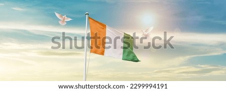 Waving flag of Ivory Coast in beautiful sky. Ivory Coast flag for independence day. Royalty-Free Stock Photo #2299994191