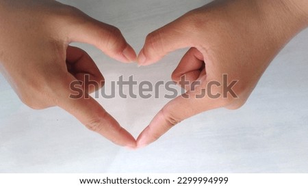 Close up of fingers forming a heart. It is usually used as a symbol of love for fellow human beings. A symbol that looks simple but is quite impressive among millennials and generation Z.