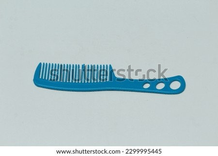 Blue plastic comb is used to comb hair.White background photo.