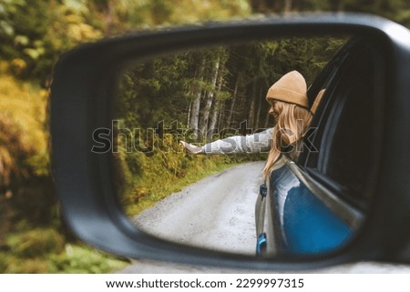 Road trip vacations woman tourist traveling by rental car active lifestyle outdoor in Norway autumn forest view mirror reflection Royalty-Free Stock Photo #2299997315