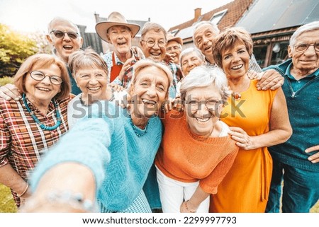 Happy group of senior people smiling at camera outdoors - Older friends taking selfie pic with smart mobile phone device - Life style concept with pensioners having fun together on summer holiday
