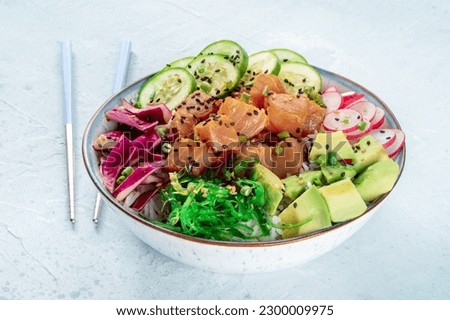 Tuna poke bowl with avocado, cucumbers, wakame, radish, and purple cabbage, a healthy Hawaiian dish, with chopsticks Royalty-Free Stock Photo #2300009975