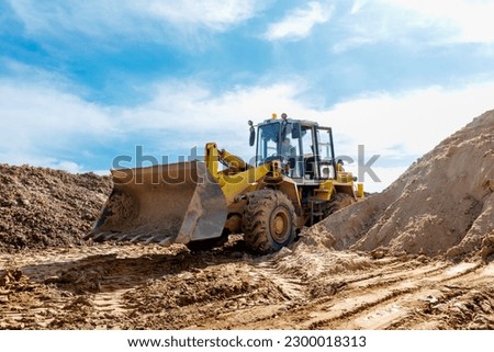 Wheel machine for loading performs work on laying large diameter pipes. Royalty-Free Stock Photo #2300018313