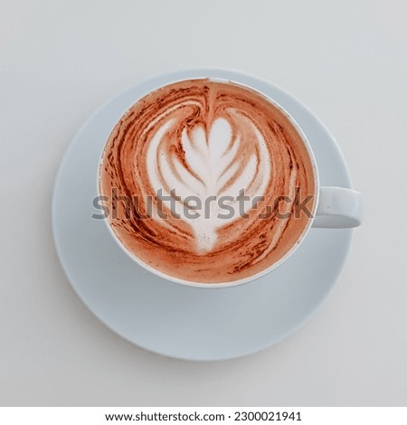 Delicious cappuccino with beautiful foam in a mug on a white background, top view. Square photo of coffee with milk