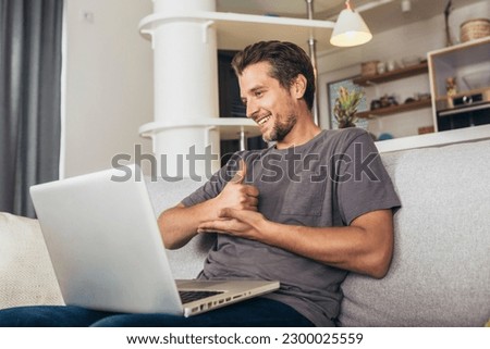 Young man showing gesture in sign language using laptop, make video call.