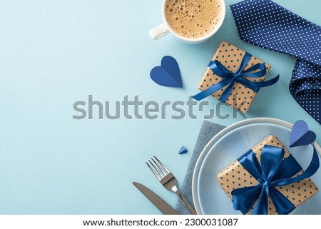 Set the tone for a memorable Father's Day celebration with this luxurious table setting featuring polished silverware, crisp linen napkins, coffee, gifts arranged elegantly on a pastel blue background Royalty-Free Stock Photo #2300031087