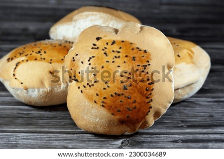 Egyptian Mahlab bread, puff thin, crispy and delicious with black seed baraka seeds on top, made of flour, dry yeast, milk, eggs, sugar, salt, black seeds, warm water, with anything or on its own Royalty-Free Stock Photo #2300034689