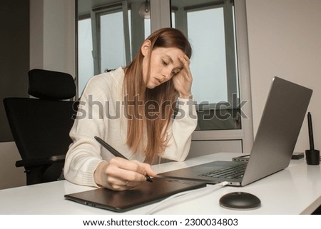 Woman work at home. Female graphic designer working at laptop. Girl work with a graphics tablet. Graphic designer artist working hard at desk.