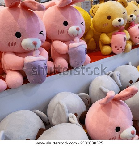 A row of dolls arranged on a shelf in a toy store supermarket