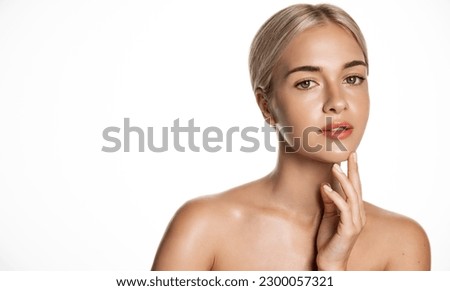 Portrait of blond beauty woman with shiny body and face, strokes her cheek after using cleaning gel, nourishing moisturizer, aha hyaluronic serum from imperfections, white background.