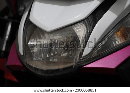 photo of a 125cc horse-powered pink and white automatic motorbike headlamp