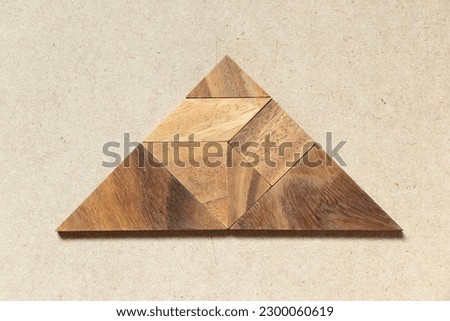 Wooden tangram in triangle shape on wood background