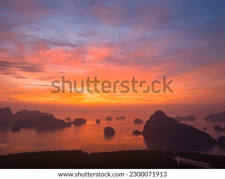 aerial view Amazing light of nature cloudscape sky above Samed Nang Chee Phang Nga archipelago. 
Imagine a fantasy bright red sky at sunrise from a bird's eye view.
tropical landscape background.