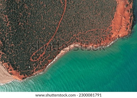 Cape Peron view from the sky. Aerial picture of orange land, long roads, a beach and the ocean in Shark Bay, Western Australia. Top down with a drone.