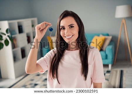 Photo of pretty adorable young girl wear pink t-shirt rising new apartment keys indoors home room