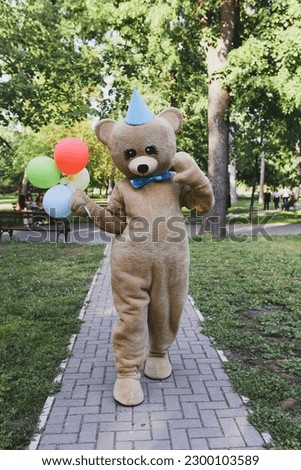 Teddy Bear mascot playing in the park Royalty-Free Stock Photo #2300103589