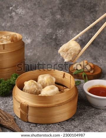 Close up shot of dim sum. Dim sum is a Chinese dish of small steamed or fried savory dumplings containing various fillings, served as a snack or main course. Royalty-Free Stock Photo #2300104987
