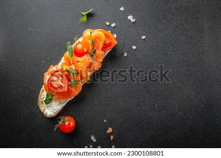 Tasty bruschetta with salmon and cream cheese on a dark background. banner, menu, recipe place for text, top view. Royalty-Free Stock Photo #2300108801