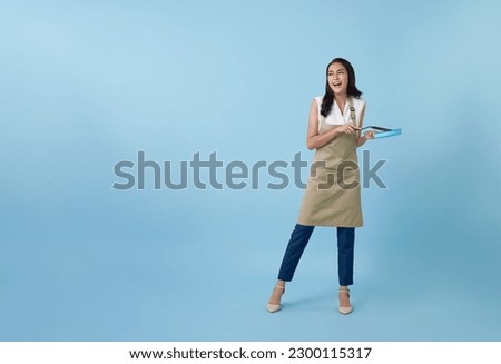 Entrepreneur Asian professional chief ready to cook, Chef holding spatula and frying pan isolated copy space on blue background. Royalty-Free Stock Photo #2300115317