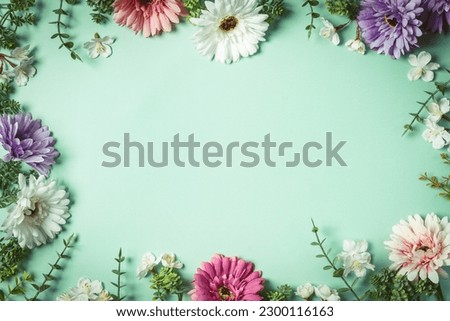 Bright summer background with pink, purple and white gerbera flowers and green leaves on green background