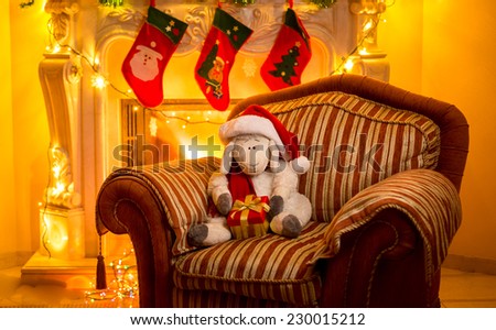 Interior photo of toy lamb sitting on chair at fireplace at Christmas 