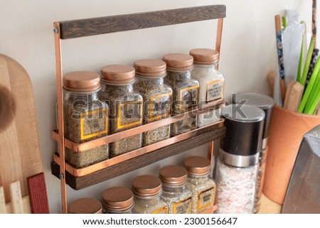 A view of a counter spice rack, seen in a home kitchen setting. Royalty-Free Stock Photo #2300156647