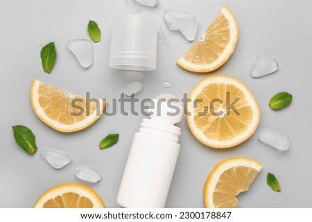 Deodorant with lemon slices, mint and ice on grey background