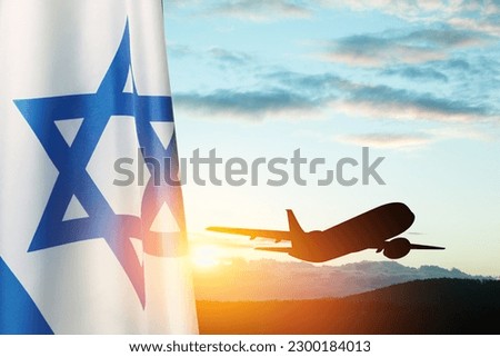 Israel flag and airplane taking off at the sunset sky. Silhouette of an airplane in the sky next to the Israeli flag. Royalty-Free Stock Photo #2300184013