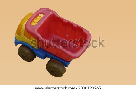 top view colorful plastic truck toy on orange background, object, toy, play, banner, template, decor, copy space 