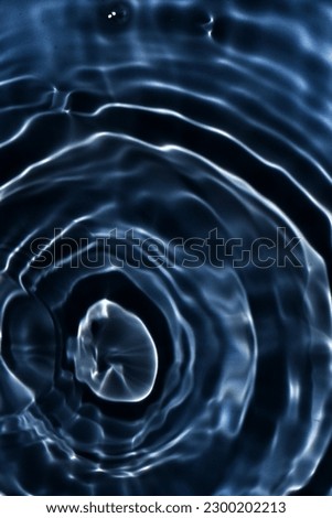 Black water with ripples on the surface. Defocus blurred transparent black colored clear calm water surface texture with splashes and bubbles. Water waves with shining pattern texture background. Royalty-Free Stock Photo #2300202213