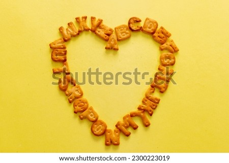This image is about Abc cookies alphabet yellow background. stock photo Heart Shape