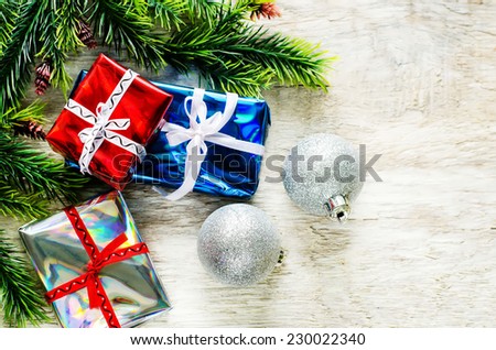 Christmas background with gifts and balls on a light woody background. tinting. selective focus on gift
