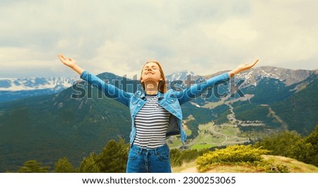 Travel concept, happy woman enjoying fresh air mountains raising her hands up on Andorra mountain background Royalty-Free Stock Photo #2300253065