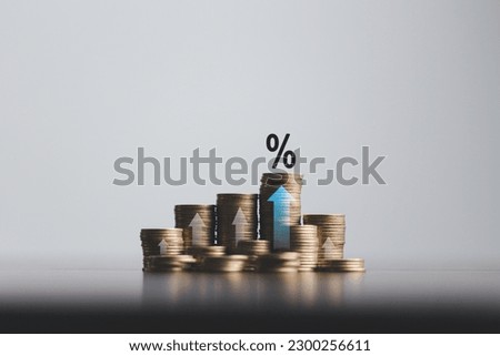 Stacked coins on wooden table with illustration shows increasing of interest rates, financial concept. Interest rate financial and mortgage rates. Icon percentage symbol and arrow pointing up.