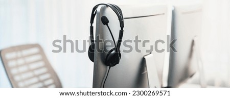 Panorama view of empty call center operator workspace, focused on headset. Representing corporate customer service support and telesales communication technology. Prodigy Royalty-Free Stock Photo #2300269571