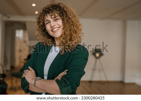 One woman caucasian female happy confident stand indoor at cafe with curly hair portrait smile real person copy space Royalty-Free Stock Photo #2300280425