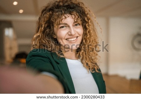 One woman caucasian female happy confident stand indoor at cafe with curly hair smile real person copy space self portrait selfie UGC User Generated Content Royalty-Free Stock Photo #2300280433
